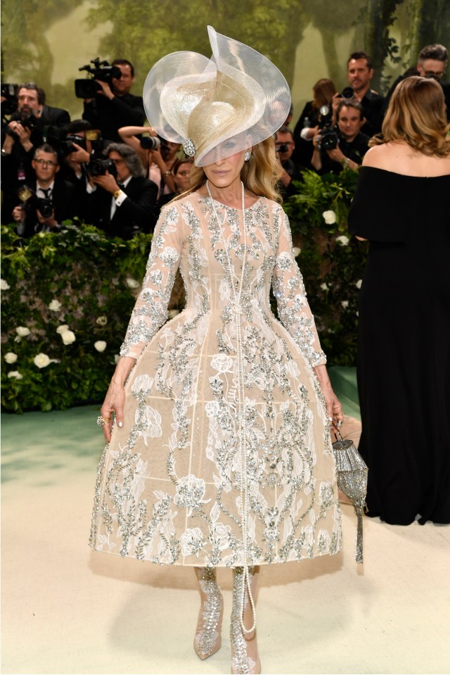 Sarah Jessica Parker at the Met Gala in a jeweled gown and elaborate hat.