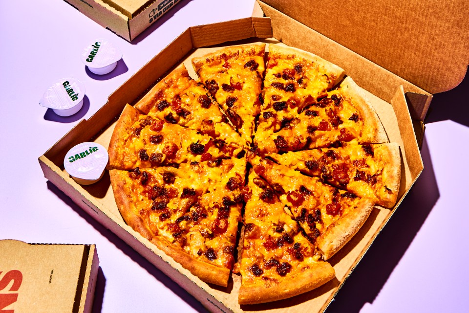 Papa John's pizza in a box with garlic sauce cups.