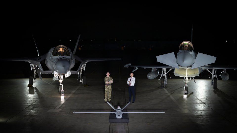 F-35B Lightning and Typhoon fighter jets with a drone and two men.