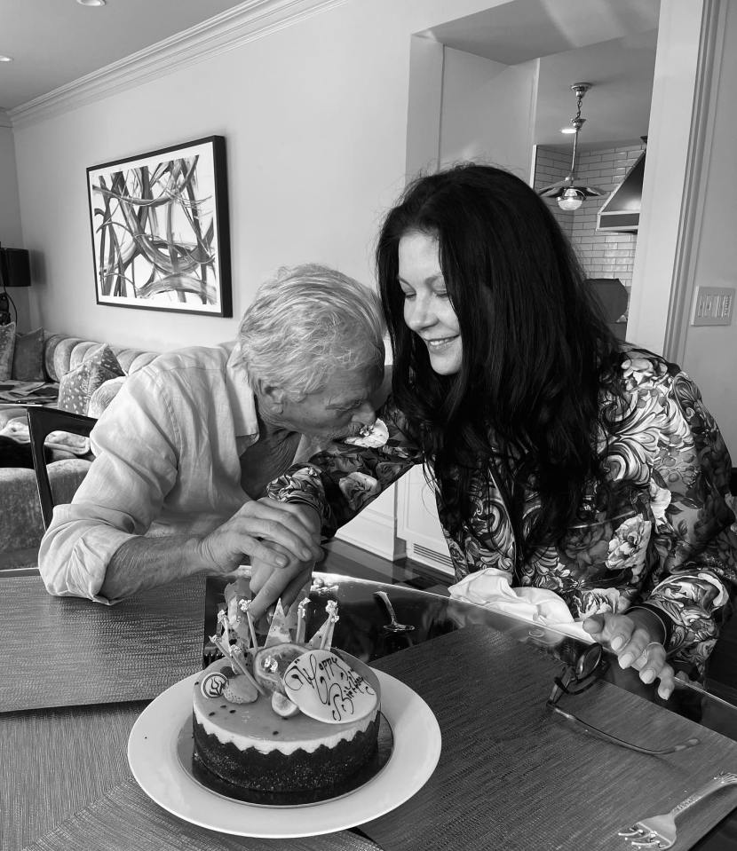 a black and white photo of a man and woman cutting a birthday cake