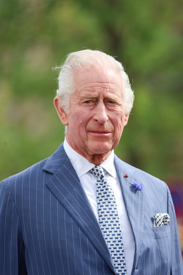 King Charles III in a blue pinstripe suit.