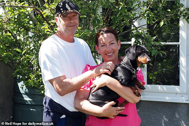 Ms Colwill and her husband, Patrick, had to sell their home and move back in with her mother for care. They are pictured with their dog Oskar