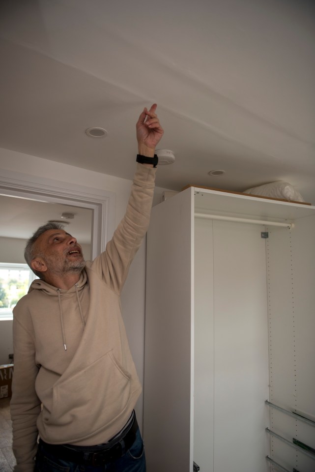 Man inspecting ceiling damage in his home.