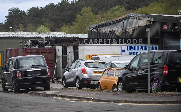 Pictured: The charred remains of a carpet shop owned by an associate of the Daniel family