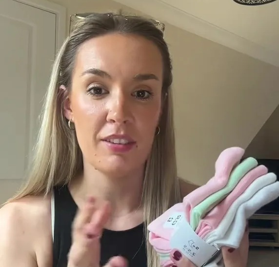 Woman holding up a pack of children's socks.