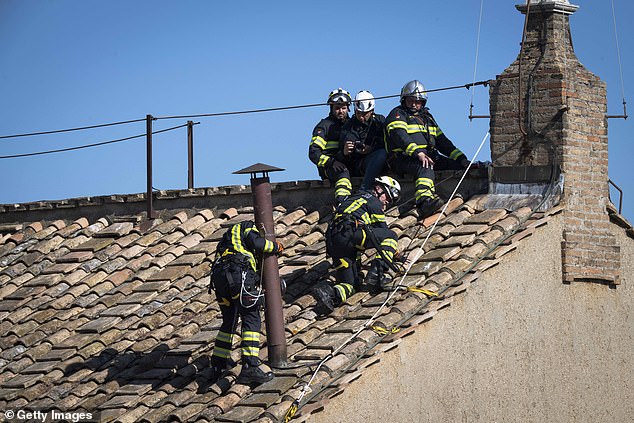 Firefighters install the chimney on the roof of the Sistine Chapel on May 02, 2025 in Vatican City, Vatican. The chimney used to communicate the choosing of a new Pope