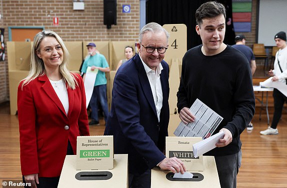 Australia's Prime Minister Anthony Albanese votes alongside his partner Jodie Haydon and his son Nathan Albanese at a polling station in Grayndler during the Australian federal election, in Sydney, Australia, May 3, 2025. REUTERS/Hollie Adams