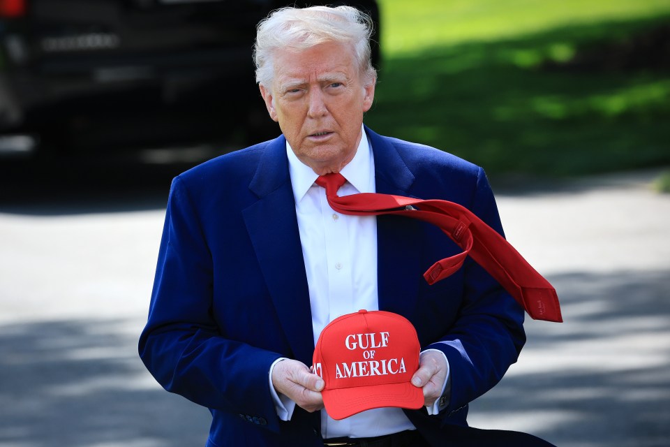 Donald Trump holding a "Gulf of America" hat.