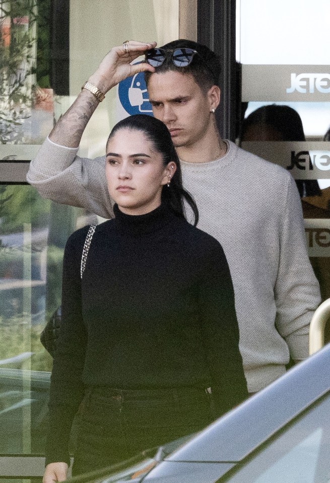 Romeo Beckham and his girlfriend arriving at an airport.
