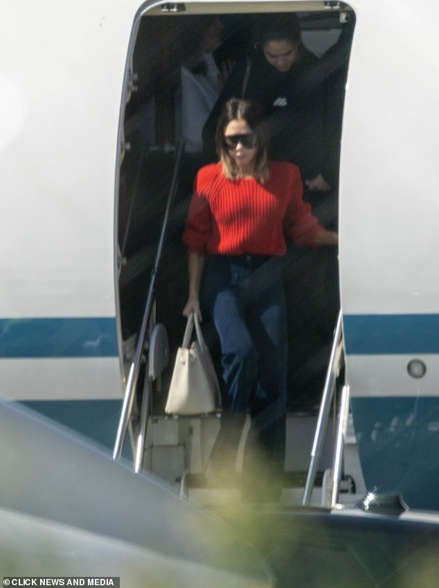 Victoria was seen emerging from the jet in a stylish red jumper and navy tailored trousers