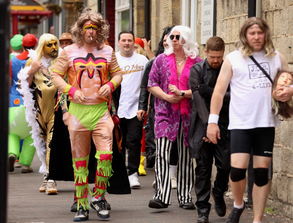 People in wrestling costumes participating in a pub crawl.