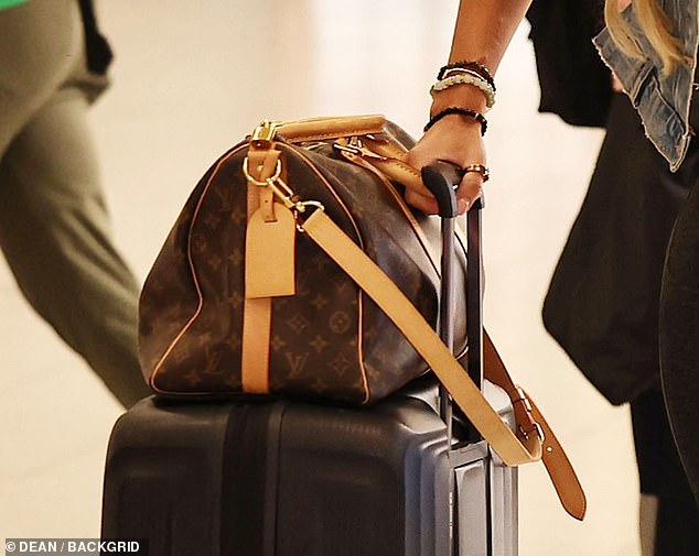 Christine had clearly packed intending to stay for the series as she wheeled her suitcase and Louis Vuitton carry on bag behind her