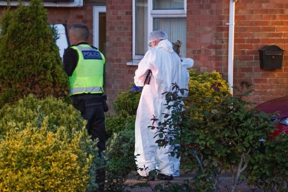 Police officers and forensic investigators at a crime scene.