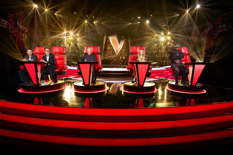 The Voice UK judges, Sir Tom Jones, LeAnn Rimes, Danny Jones and Tom Fletcher, and will.i.am, seated in their red spinning chairs on stage.
