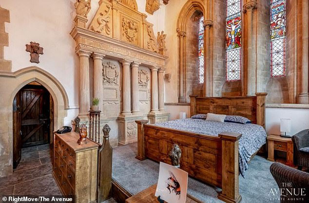 Chambers of bliss: A large bed has been positioned below one of the church's stain glass windows