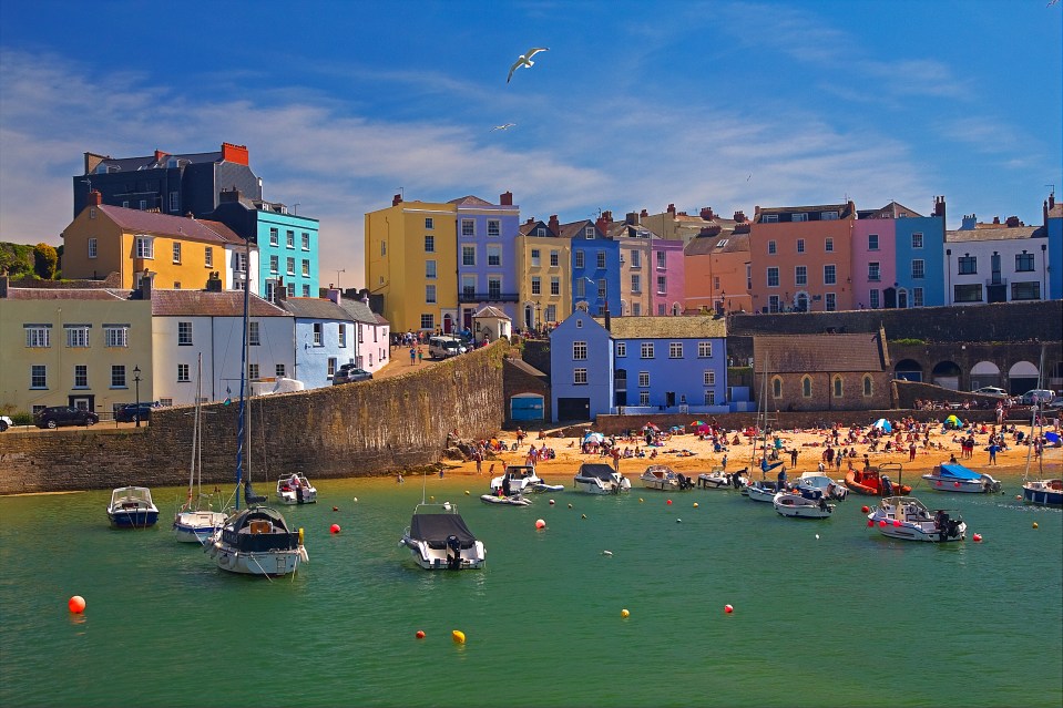 Tenby, a walled seaside town in Pembrokeshire, with colorful houses and boats in the harbor.