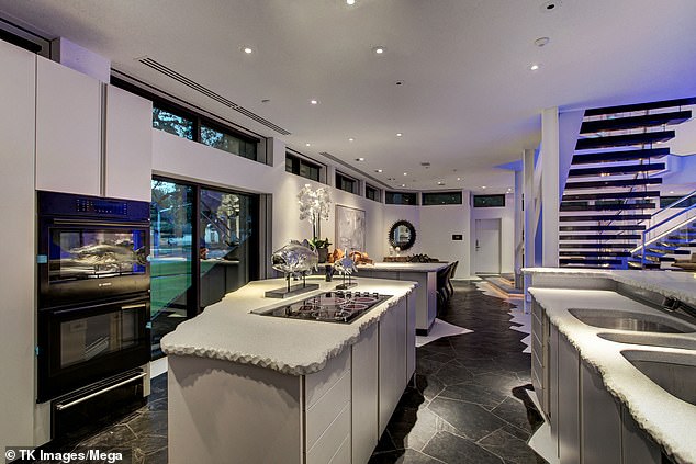 Striking angular black and white floors, crafted from concrete and hand-cut black stone, fill the home's four bedrooms and five bathrooms