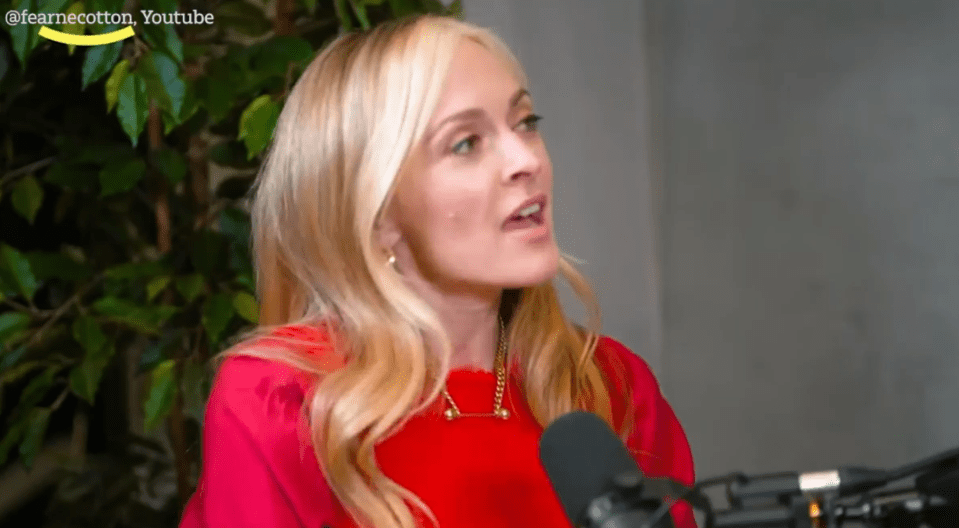 Woman in red speaking into a microphone.