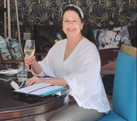 Karen Carter holding a glass of wine at a table.