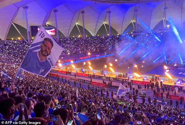 A fan waves a flag bearing the image of Brazil's forward Neymar during his unveiling at at Al-Hilal in Riyadh's King Fahd International Stadium in August 2023