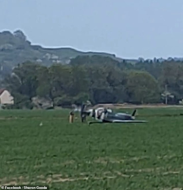Images from the incident show the warplane lying in a field as onlookers and emergency service personnel gather around it