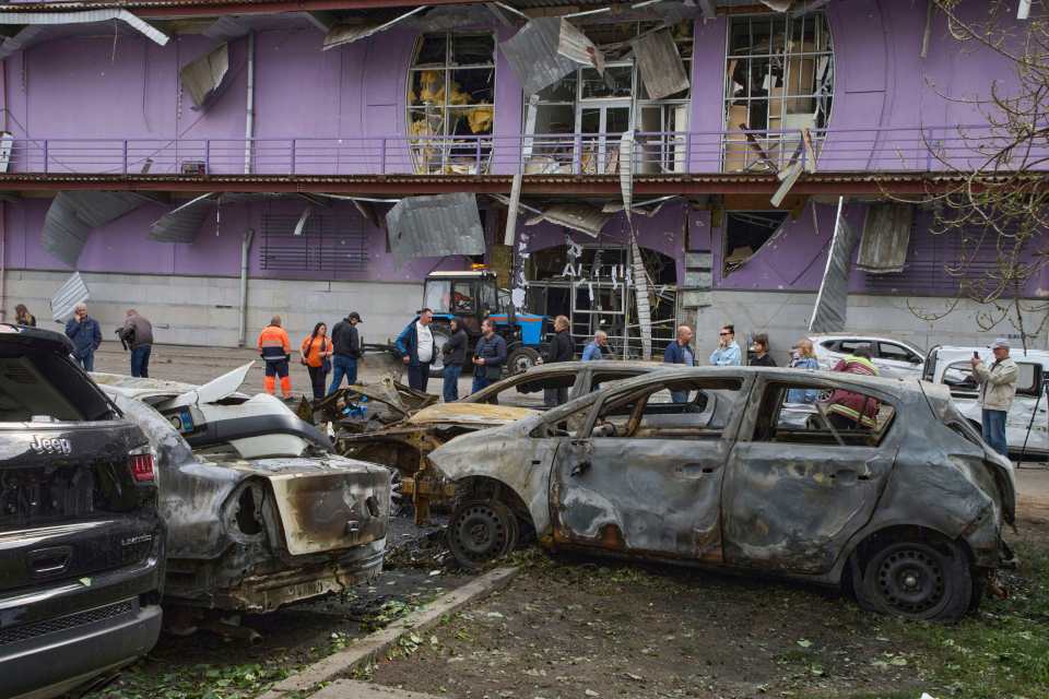 Municipal workers cleaning up burnt cars in Kyiv, Ukraine.