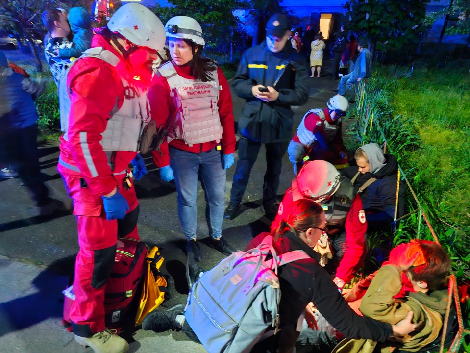 Ukrainian Red Cross paramedics providing first aid to a wounded man after a Russian drone strike in Kyiv.