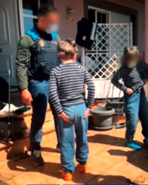 Police officer speaking with two children.
