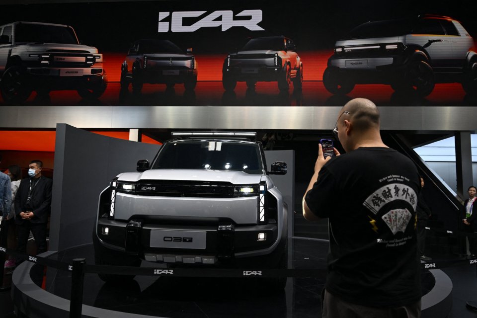 A person photographs a Chery iCar 03T at the Beijing Auto Show.