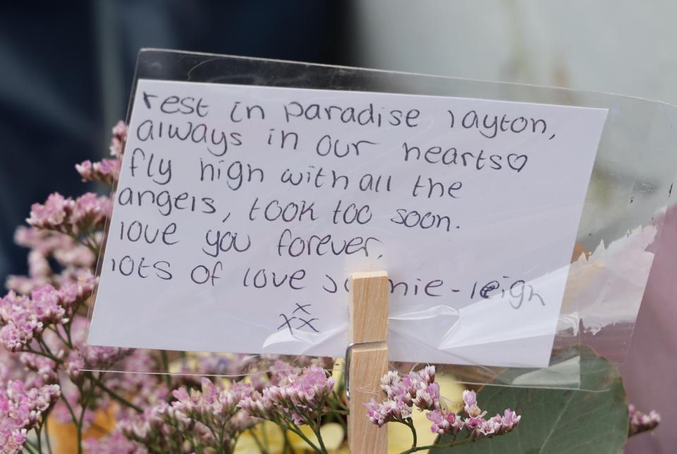 Handwritten tribute attached to flowers: "Rest in paradise Layton, always in our hearts. Fly high with all the angels, took too soon. Love you forever. Lots of love Jamie-Leigh."
