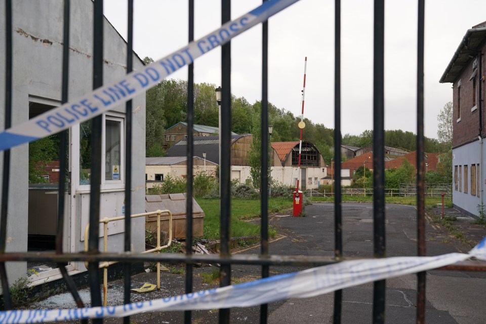 Police tape across the gates of an industrial park.