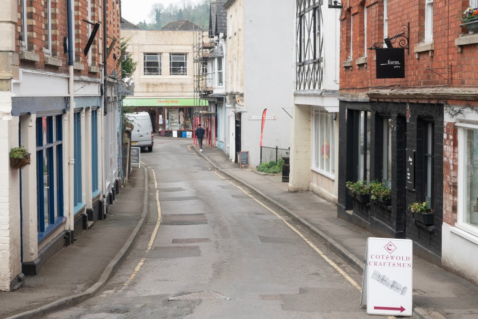 A street in Nailsworth, Gloucestershire, with shops and a damaged gas main.