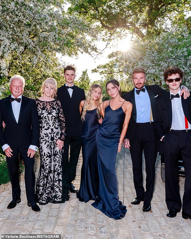 Victoria's mother and father, Jackie and Anthony, joined the family for another group snap against the stunning backdrop of the countryside evening