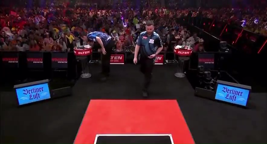 Luke Humphries at a darts match, appearing embarrassed.