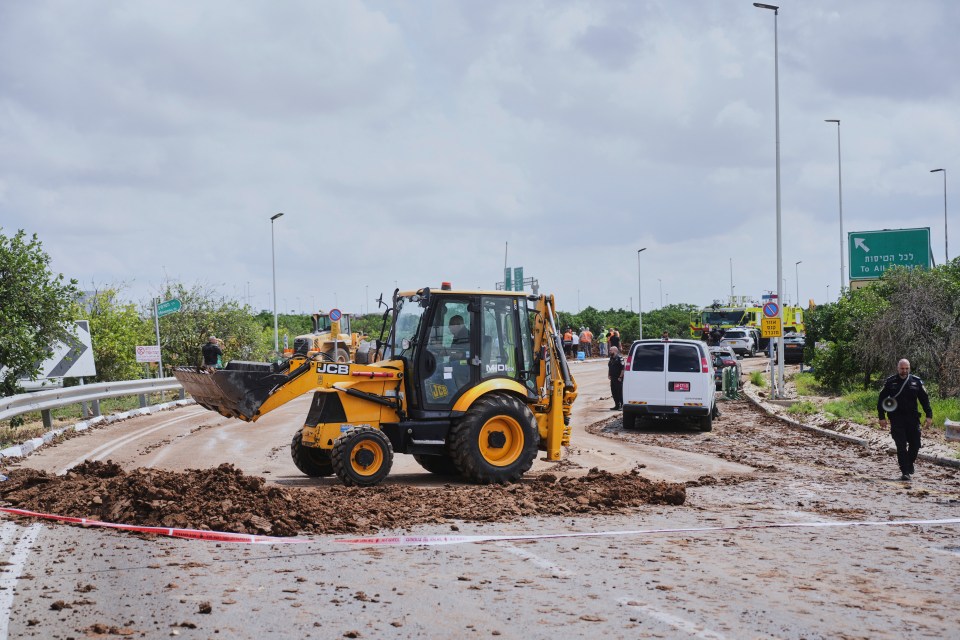 Israeli security forces clearing debris from a road near Ben Gurion Airport.