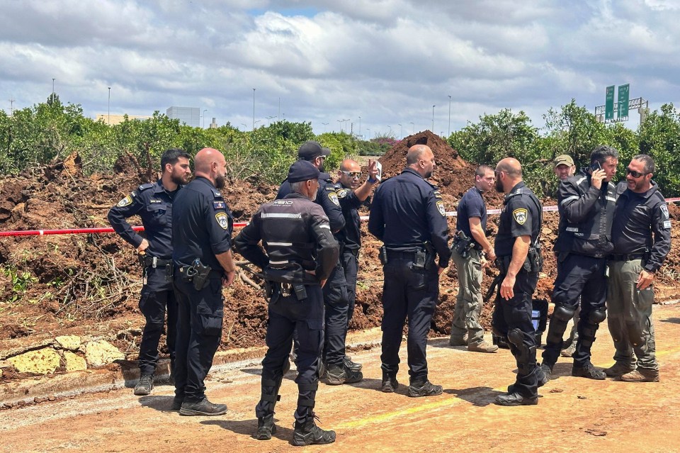 Israeli security forces clearing debris from a road near Ben Gurion Airport.
