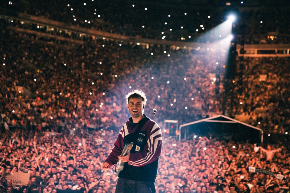 Sam Fender performing on stage in front of a large crowd.