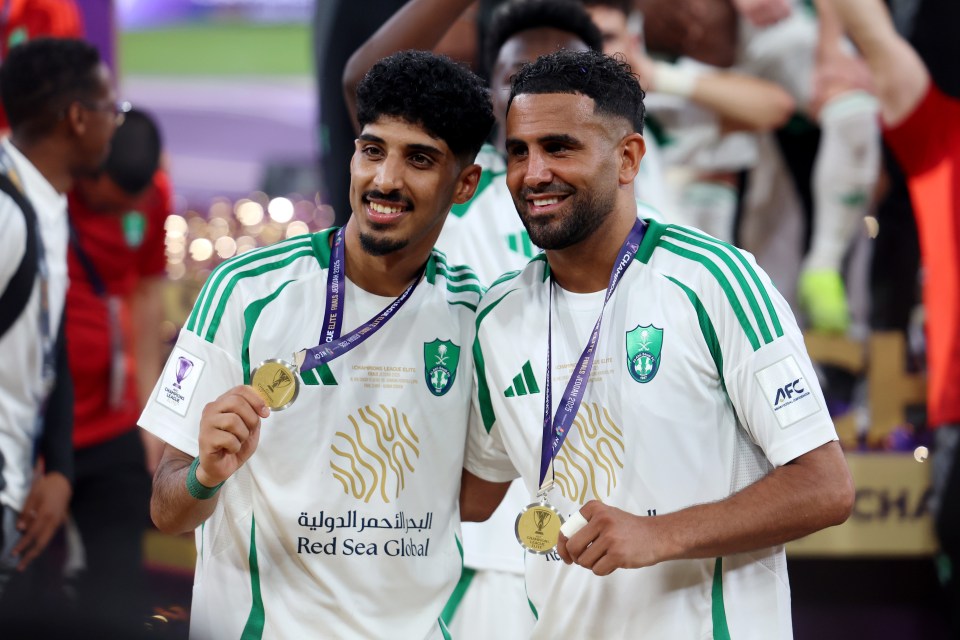 Ziyad Al-Johani and Riyad Mahrez holding their medals after an Al-Ahli victory.