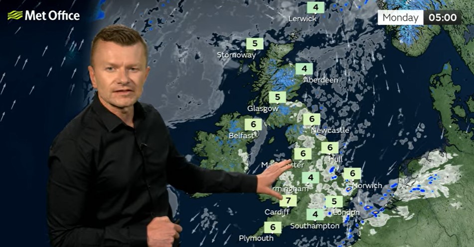 Weather presenter pointing at UK weather map showing temperature forecast.