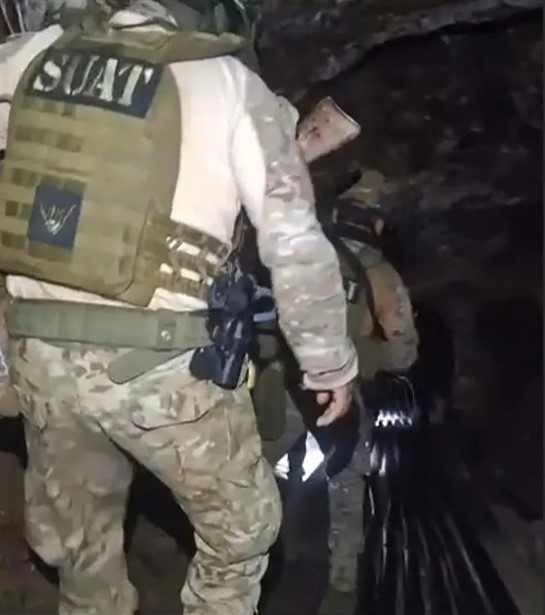 SWAT officers recovering bodies from a mine.