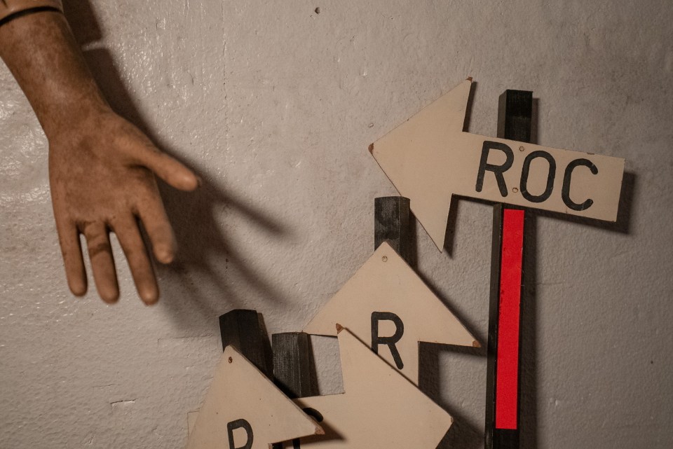 Interior of a Cold War-era bunker with directional signs.