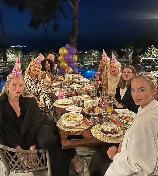 Group of women celebrating at an outdoor dinner party.