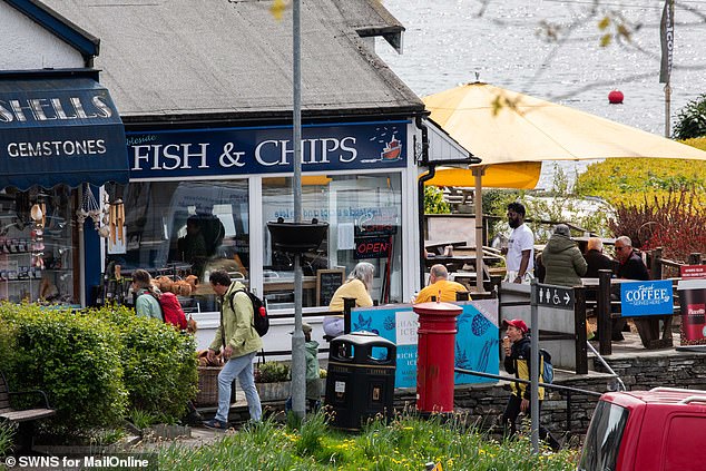 People tuck into fish and chips at the water in Ambleside. Locals say the traffic gets progressively worse as summer comes in