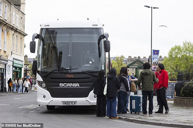 Tourists are seen standing beside a coach on Bath's Terrace Walk, next to the city centre