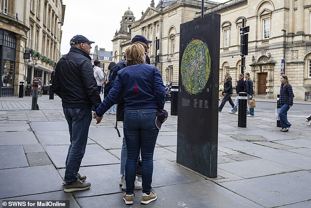 Visitors consult a city centre map of Bath. Locals say they have 'no idea' how to resolve the problem of overtourism