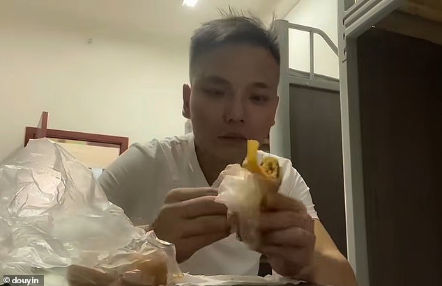 Another worker at a factory in Chongqing is seen sharing his daily routine, eating dinner in his apartment