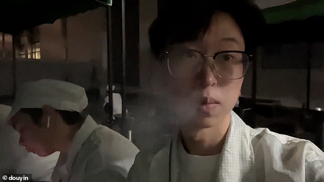 Workers take a smoke break during a 12-hour night shift at an electronics factory in Chongqing