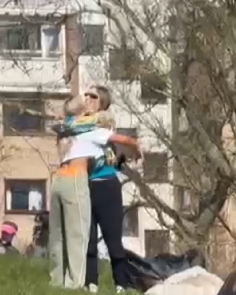 Two women embracing outdoors.