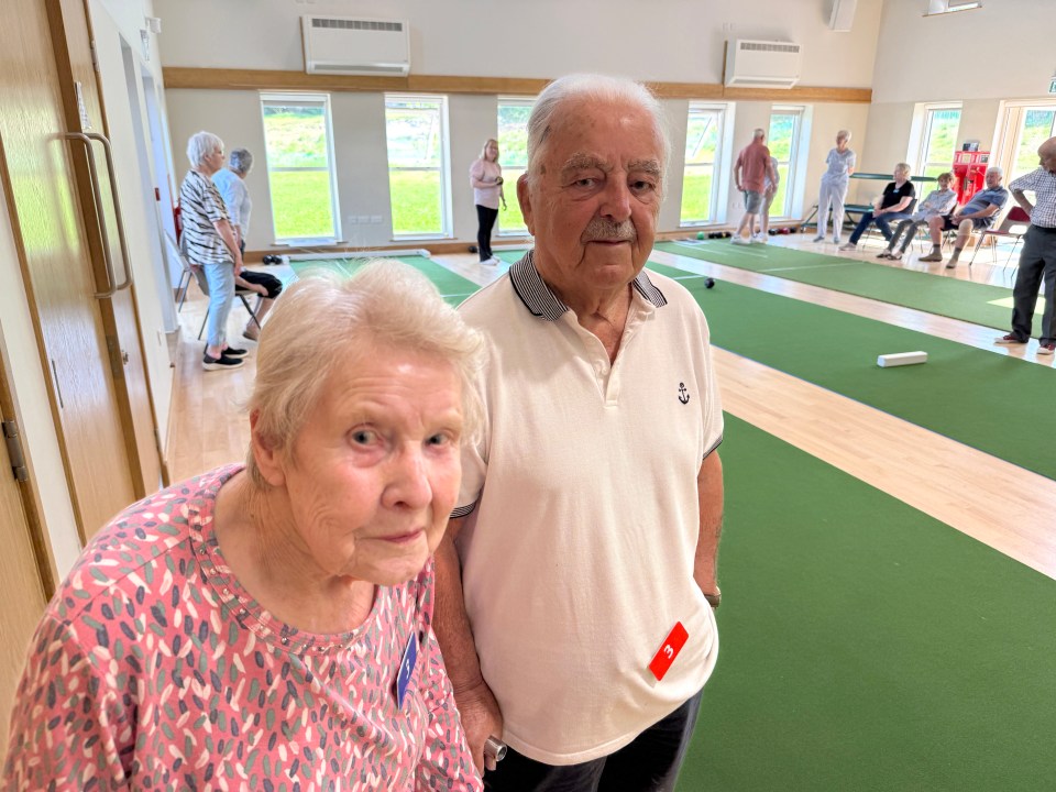 Older couple at an indoor bowling green.
