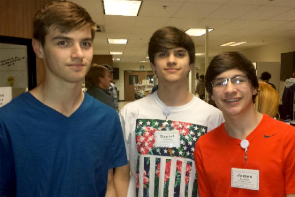 Three teenage boys wearing name tags.